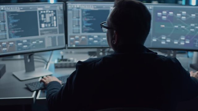 Professional IT Programer Working in Data Center on Desktop Computer with Three Displays, Doing Development of Software and Hardware. Displays Show Blockchain, Data Network Architecture Concept