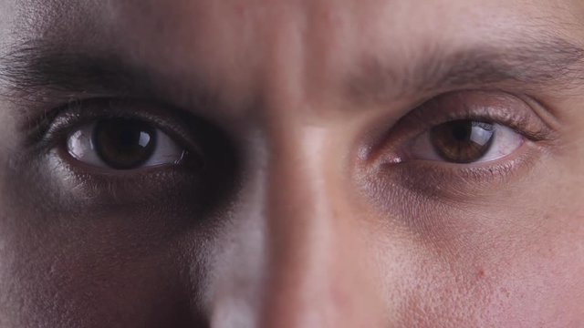 Close up Brown eyes of young man looking into camera lens. Macro