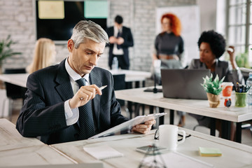 Mid adult businessman going through paperwork in the office.