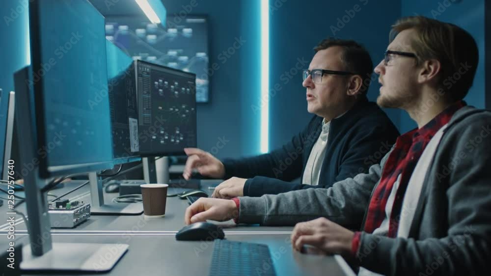 Fototapete Two Professional IT Programers Discussing Blockchain Data Network Architecture Design and Development Shown on Desktop Computer Display. Working Data Center Technical Department with Server Racks 
