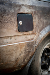 Naklejka premium A new gas fuel tank cap on a neglect vintage car.