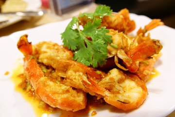 Stir-fried prawns with garlic and pepper on white dish close up