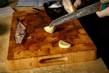 process of cutting lemon on wooden cutting board