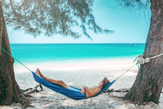 Teenage boy chilling in hammock on the beach