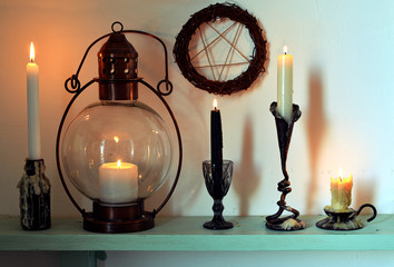 Burning candles, pentagram and old lamp on wooden shelf. Magic gothic ritual. Wicca, esoteric,...