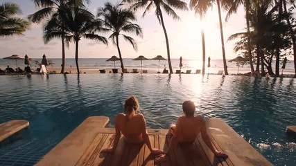 couple relaxing in luxurious beach hotel near swimming pool - Powered by Adobe