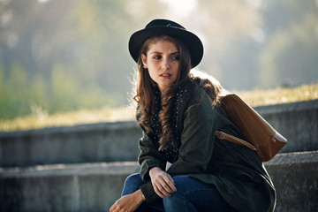 Portrait of young thoughtful woman relaxing outdoors.