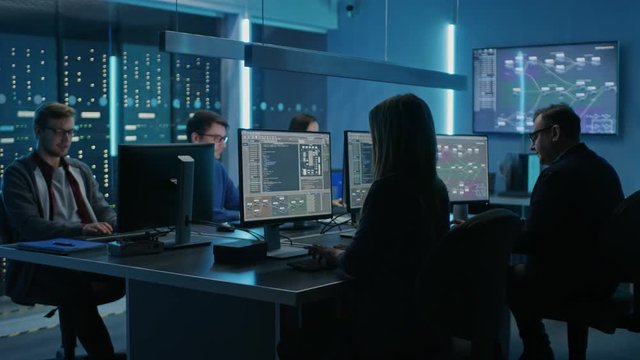 Team of Young IT Programers Working on Desktop Computers in Data Center System Control Room. Displays Show Concept: Software Development / Code Writing / Database Architecture. Technical Department