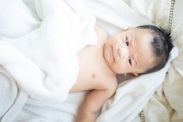 Fototapeta na wymiar Asian baby boy lying on white blanket morning wake up