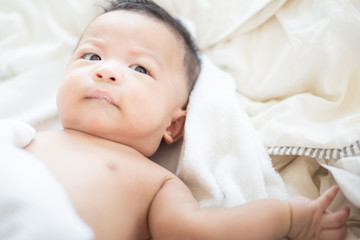 Asian baby boy lying on white blanket morning wake up