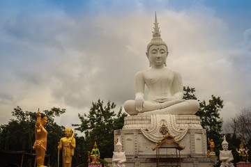 Beautiful big white buddha statue against blue sky and white cloud at the public forest temple, Wat Phu Phlan Sung, Nachaluay, Ubon Ratchathani, Thailand.