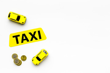 Taxi operator concept. Chip service. Price of services. Sign taxi ner car toy and coins on white...