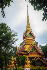 Fototapeta premium Beautiful golden pagoda with decorative Thai style fine art at public Buddhist Wat Phu Phlan Sung, Nachaluay, Ubon Ratchathani, Thailand.