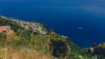 Fototapeta na wymiar Town by blue sea and coastline of Amalfi Coast from Path of the Gods, near Positano, Italy
