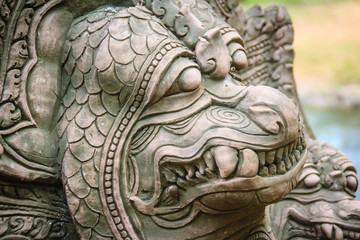 Khmer' s style Naga head made from sand stone at the public temple in Thailand. Naga or large snake according to Hindu belief. - obrazy, fototapety, plakaty