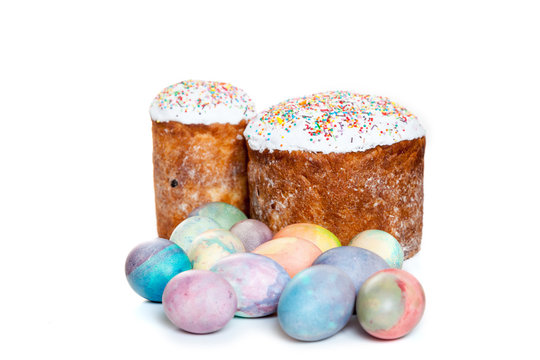 Two Easter cakes and colorful eggs on white background