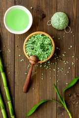 Spa composition. Natural asian spa cosmetics near bamboo on dark wooden background top view