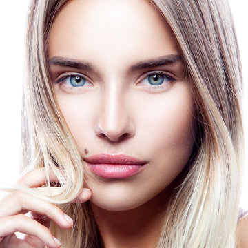 Close-up beauty face of young model girl with healthy clean fresh skin, natural make-up, blond hair, blue eyes. Attractive pretty woman. Skincare facial treatment concept