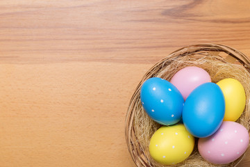 Easter eggs in the basket on wooden background