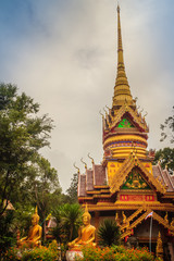 Fototapeta premium Beautiful golden pagoda with decorative Thai style fine art at public Buddhist Wat Phu Phlan Sung temple, Nachaluay, Ubon Ratchathani, Thailand.