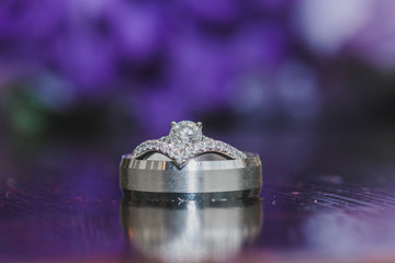 silver wedding rings  with reflection and purple bokeh background