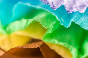 Multi-colored crumpled real vivid paper sheets texture background. Close up. Shallow depth of field.