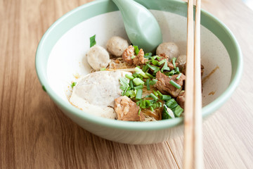 Dry noodle have meatball Braised pork and pork Tofu in the big bowl put on the wood table 