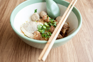 Dry noodle have meatball Braised pork and pork Tofu in the big bowl put on the wood table 