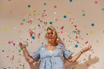 A young happy blond woman against colourful background