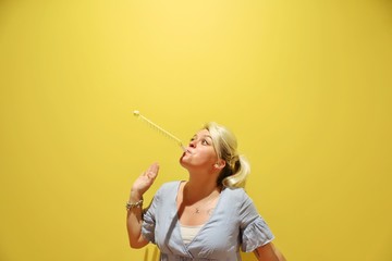 A young happy blond woman against colourful background