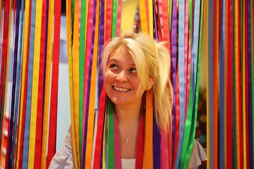 A young happy blond woman against colourful background