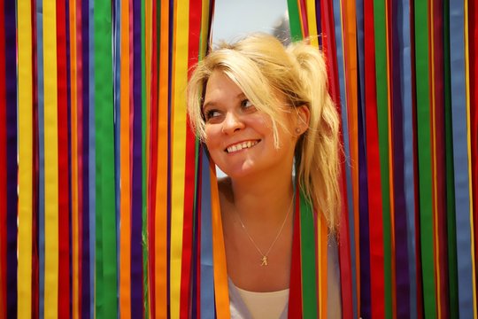 A young happy blond woman against colourful background