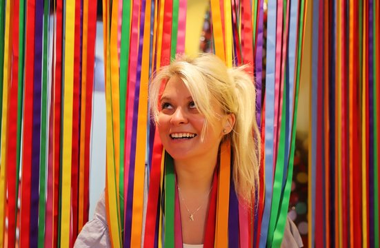 A young happy blond woman against colourful background