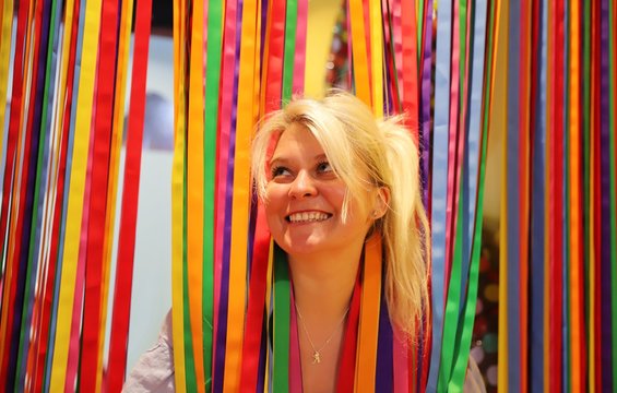 A young happy blond woman against colourful background