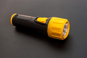 Yellow and black LED Flashlight on the black background, Emergency tool for darkness 
