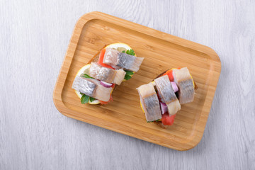 toast with lemon and parsley, ginger and herring on a wooden plate