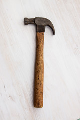 vintage old hammer steel handle tool on wood white paint background