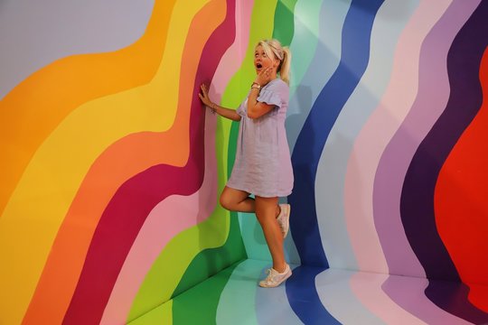 A young happy blond woman against colourful background