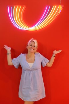 A young happy blond woman against colourful background