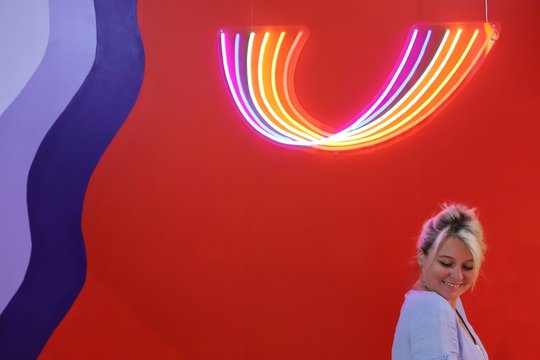 A young happy blond woman against colourful background