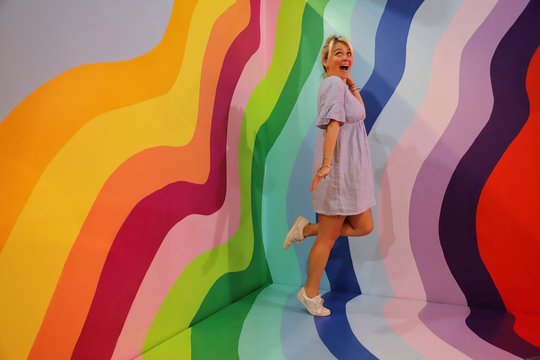 A young happy blond woman against colourful background