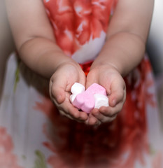 the child is holding pink and white hearts. symbol of love, family, Hope