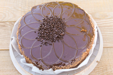 Big chocolate cake on wooden table. Top view