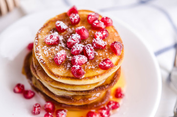 Pancakes with pomegranate seeds, honey and powdered sugar