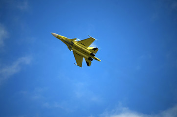 Unpainted military aircraft flying in the sky on a demonstration performance