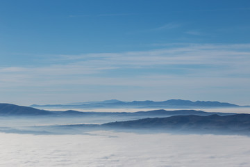 Fototapeta na wymiar Fog filling a valley in Umbria (Italy), with layers of mountains and hills, various shades of blue