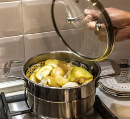 A pot with a vegetables standing on the stove,