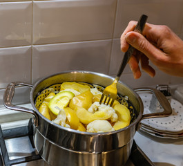 A pot with a vegetables standing on the stove,