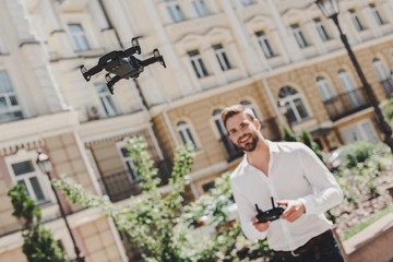 Fototapeta premium Leisure time. Man operating drone. Flying or hovering by remote control outdoors