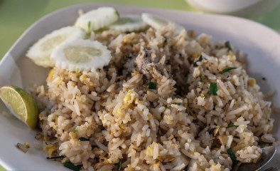 Fried rice with chicken. Prepared and served in a wok. Natural wood in the background. Top view.